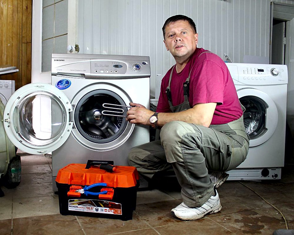 Мастер ремонтирует нагрев стиральной машины